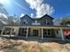 Two-story home with gray siding, covered porch supported by white columns and a front door with glass panels at 335 Ruth Blvd, Longwood, FL 32750