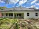 Back exterior view of a home featuring a covered patio with pillars and multiple windows at 335 Ruth Blvd, Longwood, FL 32750