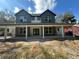 Two-story home featuring gray vertical siding, a covered porch with white columns and green double doors at 335 Ruth Blvd, Longwood, FL 32750
