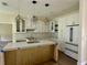 Kitchen with white cabinets, eat-in island, quartz countertops, stainless steel appliances and wood flooring at 335 Ruth Blvd, Longwood, FL 32750