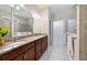 Bright bathroom featuring dual sinks, dark wood cabinets and a tiled glass shower at 3629 Vega Creek Dr, St Cloud, FL 34772