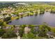 Panoramic aerial view of a community surrounding a lake, featuring lush green trees and well-maintained homes at 383 Brushwood Ln, Winter Springs, FL 32708