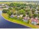 An aerial shows backyard pools and lush tree coverage in this neighborhood next to the lake at 383 Brushwood Ln, Winter Springs, FL 32708