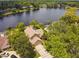Aerial view of the home and the serene lake, surrounded by lush greenery, and a screened-in pool at 383 Brushwood Ln, Winter Springs, FL 32708
