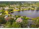 Aerial view of homes in a community nestled around a lake, surrounded by lush green trees and landscaping at 383 Brushwood Ln, Winter Springs, FL 32708