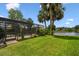 Landscaped backyard featuring a lake view, patio, and screened pool enclosure at 383 Brushwood Ln, Winter Springs, FL 32708