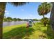 Waterfront backyard with a playset and mature palms offer a scenic view at 383 Brushwood Ln, Winter Springs, FL 32708