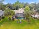 Aerial view of a large backyard with screened pool, tall palm trees, and a playground at 383 Brushwood Ln, Winter Springs, FL 32708