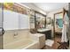 A bathroom with a tub, tiled floor, double sinks, and view into an adjacent bedroom at 383 Brushwood Ln, Winter Springs, FL 32708