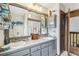 Well-lit bathroom with double sink vanity, rustic mirror, and an open doorway to the hallway at 383 Brushwood Ln, Winter Springs, FL 32708