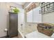 Bright bathroom featuring a tub with white tiles, storage cabinet, and a window with floral decor at 383 Brushwood Ln, Winter Springs, FL 32708