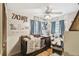 Bedroom featuring hardwood floors, a crib, a comfortable chair, wall art and decor shelving at 383 Brushwood Ln, Winter Springs, FL 32708