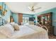 Bright bedroom featuring a white iron bed, wooden dresser, ceiling fan, and a view of the sparkling pool at 383 Brushwood Ln, Winter Springs, FL 32708
