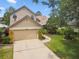 Charming two-story home featuring a spacious garage, manicured landscaping, and a welcoming walkway at 383 Brushwood Ln, Winter Springs, FL 32708