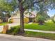 Two-story tan home with a well-kept lawn, mature trees, and a charming brick mailbox at 383 Brushwood Ln, Winter Springs, FL 32708