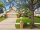 Two-story home with a well-manicured front yard, beautiful trees, and a charming mailbox at 383 Brushwood Ln, Winter Springs, FL 32708
