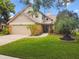 Charming two-story home featuring a well-manicured lawn and beautiful landscaping at 383 Brushwood Ln, Winter Springs, FL 32708
