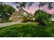 Charming two-story home featuring a well-maintained lawn, mature trees, and inviting curb appeal at sunset at 383 Brushwood Ln, Winter Springs, FL 32708
