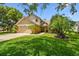 Two-story tan home with a well-kept lawn and mature landscaping at 383 Brushwood Ln, Winter Springs, FL 32708