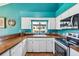 Bright kitchen featuring butcher block countertops, colorful backsplash, and white cabinetry at 383 Brushwood Ln, Winter Springs, FL 32708