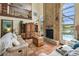 Comfortable living room boasts a brick fireplace, tiled floors, and staircase leading to the upper level at 383 Brushwood Ln, Winter Springs, FL 32708
