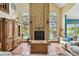 Bright living room featuring a brick fireplace and views of the pool through arched windows at 383 Brushwood Ln, Winter Springs, FL 32708