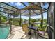 Outdoor dining with a patio set under an umbrella, near a screened pool, and a lake backdrop at 383 Brushwood Ln, Winter Springs, FL 32708