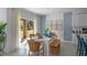 Bright dining area with a white table, stylish rattan chairs, and access to the outdoor space at 3896 Diving Dove Ln, Bartow, FL 33830