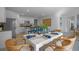 Open-concept dining area with a white table, rattan chairs, and modern kitchen features at 3896 Diving Dove Ln, Bartow, FL 33830