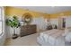 Bright bedroom with a comfy bed, white wainscoting on the walls, a stylish dresser, and a large potted plant at 3908 Diving Dove Ln, Bartow, FL 33830