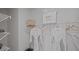 Neat walk-in closet with storage shelves, hanging rods, City Furniture shopping bag, and neatly hung white bathrobes at 3908 Diving Dove Ln, Bartow, FL 33830