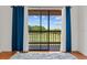 A cozy balcony with view of outdoor green area, wooden railings, and beautiful curtains at 3928 Villas Green Cir, Longwood, FL 32779
