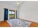 Bright bedroom featuring hardwood floors, ceiling fan, and sliding glass doors to the outside at 3928 Villas Green Cir, Longwood, FL 32779