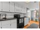 Bright kitchen features white cabinets, black countertops, and modern appliances at 3928 Villas Green Cir, Longwood, FL 32779