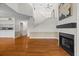 Open-concept living space with hardwood floors, fireplace, and an adjacent staircase at 3928 Villas Green Cir, Longwood, FL 32779