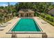 A community pool is surrounded by lounge chairs and lush landscaping at 3928 Villas Green Cir, Longwood, FL 32779