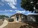 Inviting single-story home with a blue door and arched windows, set under a bright blue sky at 410 Horizon Dr, Winter Springs, FL 32708