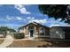 Inviting single-story home with a blue door and arched windows, set under a bright blue sky at 410 Horizon Dr, Winter Springs, FL 32708