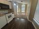 Open-concept kitchen with dark floors, white appliances and an arched window looking into the living area at 410 Horizon Dr, Winter Springs, FL 32708