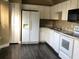 Efficient kitchen with white appliances, ample cabinet space, and sleek dark wood flooring at 410 Horizon Dr, Winter Springs, FL 32708