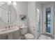 Bright bathroom featuring a stylish single sink, toilet, and glass door shower at 5108 Sailwind Cir, Orlando, FL 32810