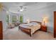 Primary bedroom featuring large windows, tray ceilings, and a ceiling fan at 5108 Sailwind Cir, Orlando, FL 32810
