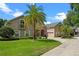 Lovely two-story home exterior with well-manicured lawn, mature palm trees, and a basketball hoop at 5108 Sailwind Cir, Orlando, FL 32810