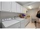 Organized laundry room area with front load washer and dryer with plenty of storage space at 5108 Sailwind Cir, Orlando, FL 32810