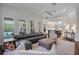 A spacious living room features a comfortable sectional couch, a ceiling fan, and views of the pool at 5108 Sailwind Cir, Orlando, FL 32810