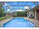 Stunning in-ground pool featuring screened enclosure, paver deck, and manicured landscaping at 5108 Sailwind Cir, Orlando, FL 32810
