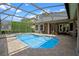 Sparkling in-ground pool featuring screened enclosure, paver deck, and lush landscaping for privacy at 5108 Sailwind Cir, Orlando, FL 32810