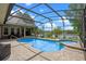Stunning screened-in pool and spa with a serene lake view, perfect for relaxation and outdoor entertaining at 5108 Sailwind Cir, Orlando, FL 32810