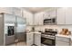 Modern kitchen with stainless steel appliances, gray cabinets, and white countertops at 5113 Forget Me Not Ave, Lake Hamilton, FL 33851