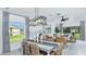 A bright living room showcases neutral decor, stylish lighting, and inviting seating with a view of the outdoors at 5113 Forget Me Not Ave, Lake Hamilton, FL 33851